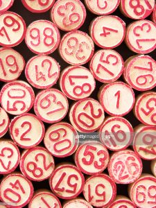 Pieces of cheap bingo game showing numbers. Top view, full frame